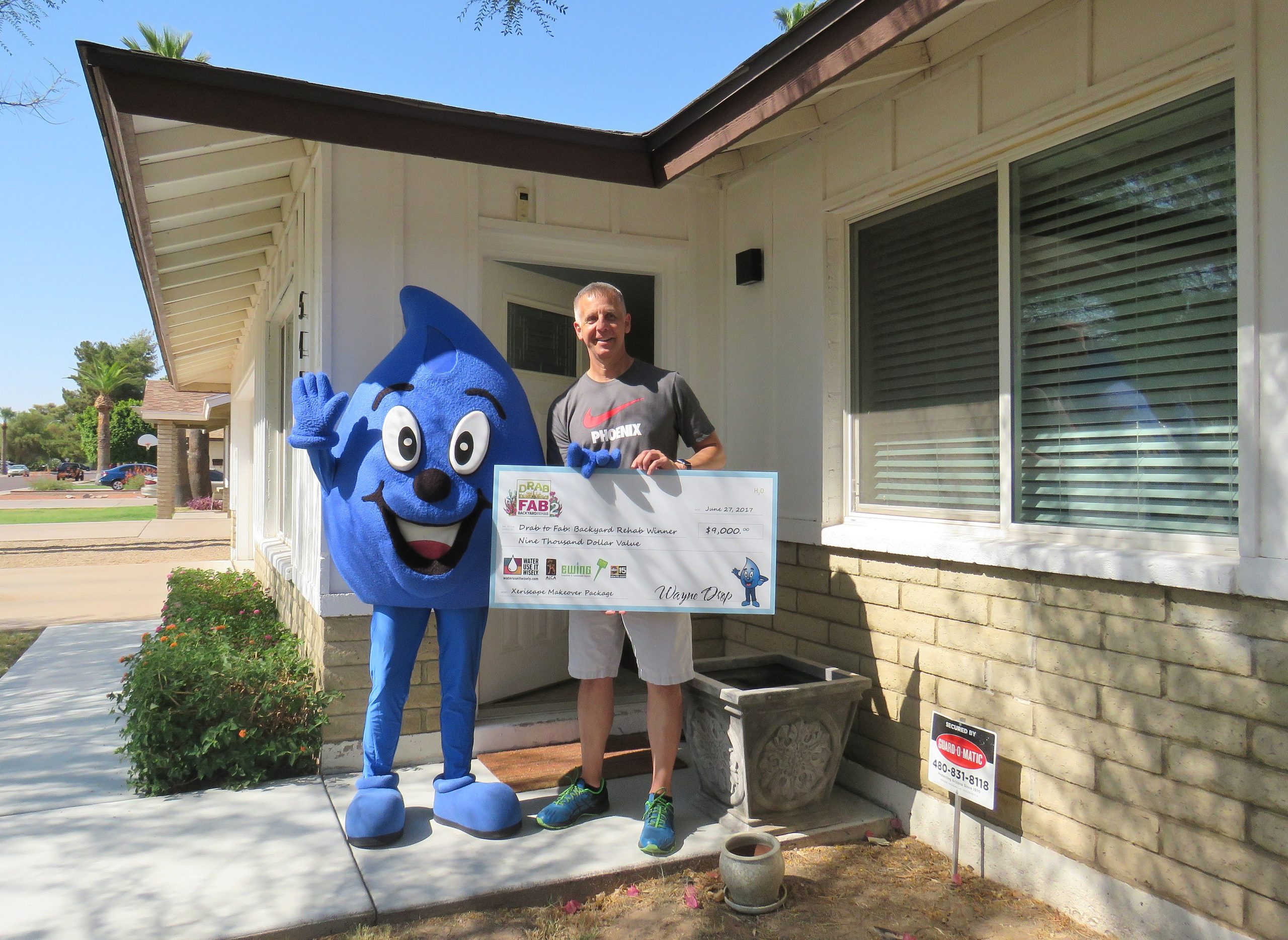 The winner of the Drab to Fab Backyard Rehab with Wayne Drop and check
